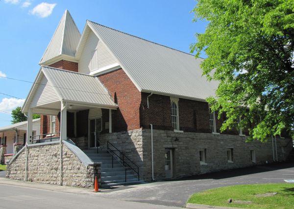 Brick church with a steep gabled roof on a stone foundation