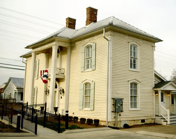 Cream-colored two-story Italianate house with tall windows