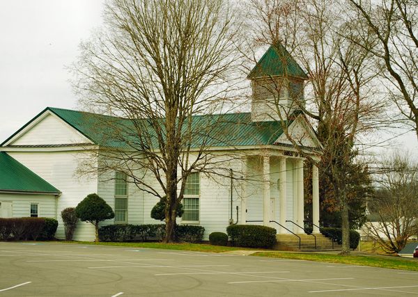 White frame church with a green roof and small steeple