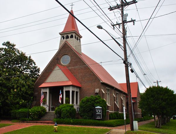 Red brick Gothic church with a pointed bell tower