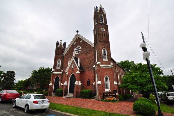 Red brick church with twin towers of different heights