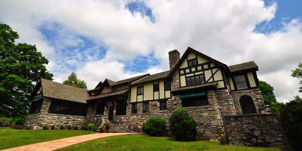 Large Tudor-style stone and timber manor house on a lawn