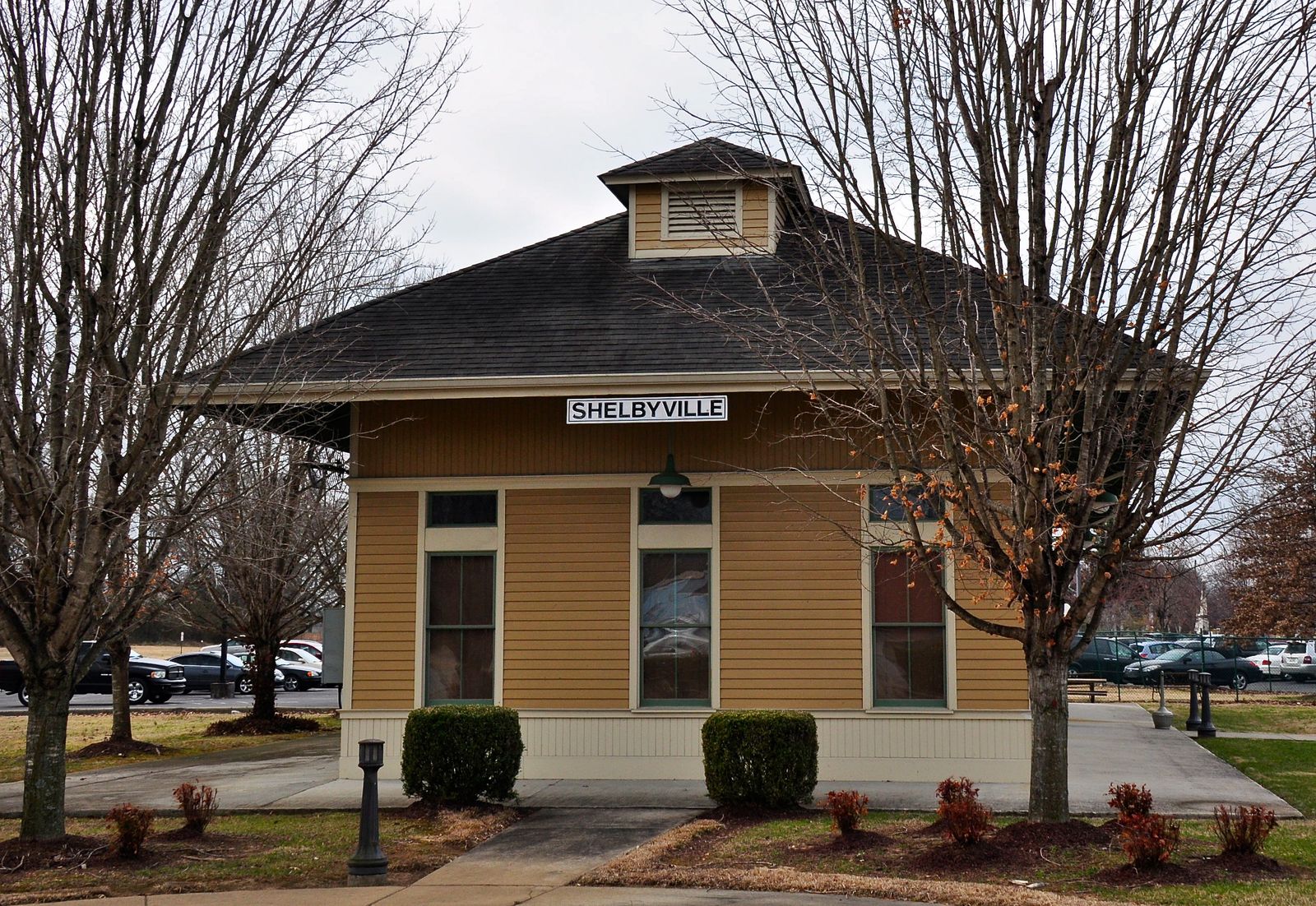 A small yellow frame railroad depot with a dark roof