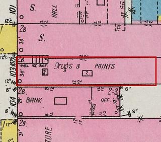 September 1926 Sanborn fire insurance map detail with the lot at today&rsquo;s 106 Elk Ave. S. (storefront 2 of 2) outlined in red; the map labels it: drugs and paints