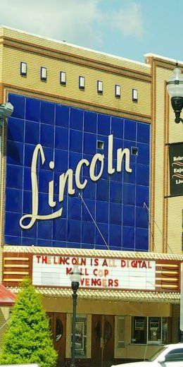 Front of the Lincoln Theatre: a tall blue tile panel with Lincoln in white script above the marquee, yellow brick on each side, College St. E., 2015